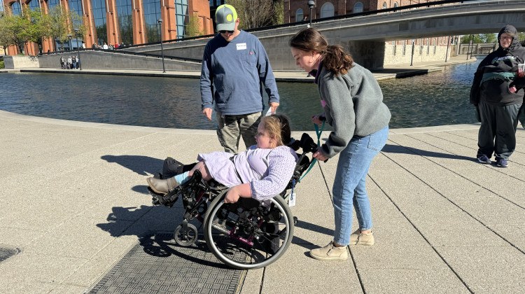 Occupational therapist and Skills on Wheels volunteer Maria Fuchs guides 12-year-old Savannah Healton through some wheelchair skills. Savannah's parents, Matthew White and Chanda Healton, observe and learn to be able to help her as she practices. - Elizabeth Gabriel / Side Effects Public Media