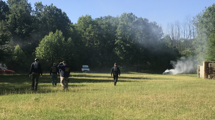 Safety officials check the exploded cars before IUPUI students investigate the wreckage at Eagle Creek Pistol Range on Friday, June 14, 2019. - Emily Cox/WFYI News