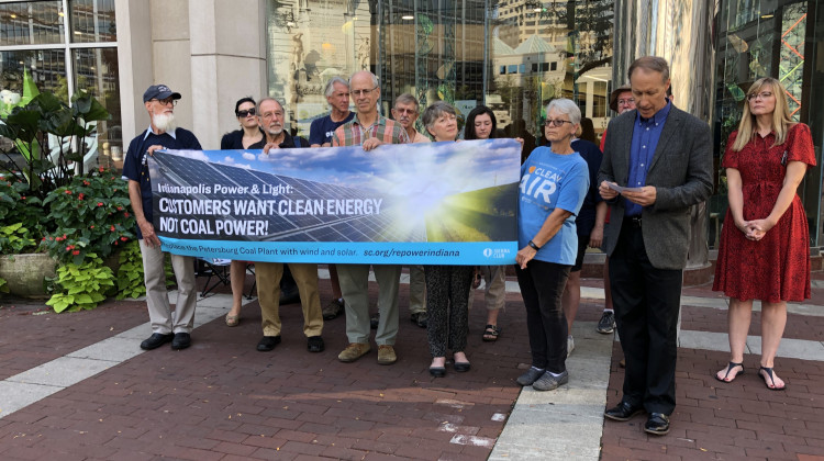 Environmental activists hold a banner recreation of the billboard placed on 38th street.  - Darian Benson/ WFYI