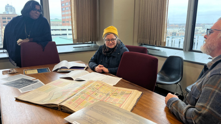 Deputy Mayor Judith Thomas, historian DeeDee Davis and archaeologist Ryan Peterson look at archival records. - Jill Sheridan / WFYI
