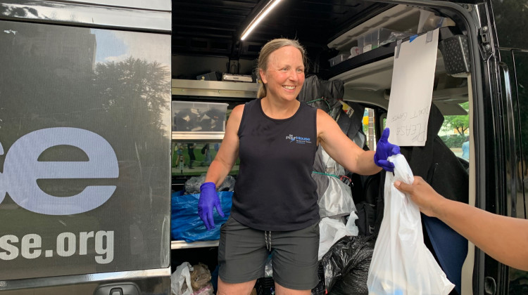 Andrea DeMink with the Pour House hands out dinner. - Jill Sheridan/WFYI