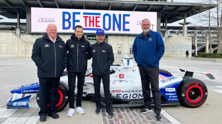 Gov. Eric Holcomb (right) stands next to Tony Kanaan, 2013 Indy 500 race winner and Chip Ganassi (left), owner of Chip Ganassi Racing. - (Farah Yousry/ WFYI)