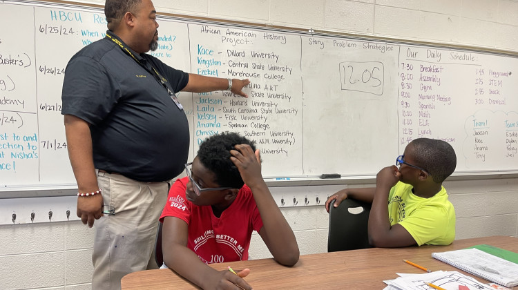 Marcus Hatcher with 100 Black Men of Indianapolis points to a list of historically Black colleges. - Sydney Dauphinais / WFYI