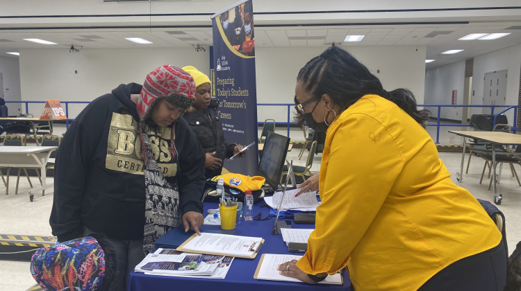 Former HIM By HER parent Samone Curry talked to an employee with Indy STEAM Academy during a school enrollment at HIM By HER Collegiate School for the Arts, which will close in January 2023.  - Elizabeth Gabriel/WFYI News
