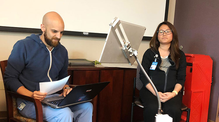 Adam Paarlberg (left) and medical assistant Ngun Tial (right) demonstrate how the live interpreter MARTI system works. - Carter Barrett/Side Effects Public Media