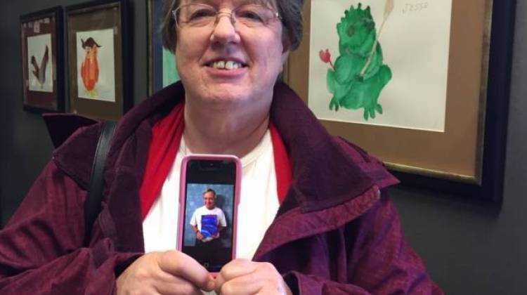 Caregiver Sheryl Chamberlain holds her smart phone with a picture of her husband Roger.