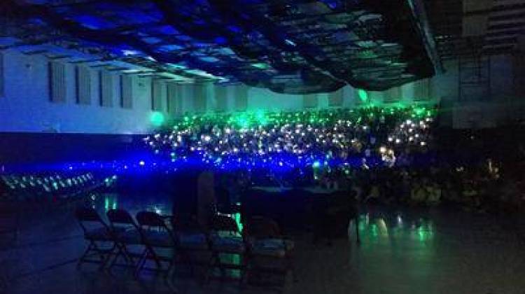 Cumberland Elementary students shine lights in their gymnasium to emulate fireflies as Gov. Holcomb arrives to sign the bill. - Emilie Syberg / WBAA