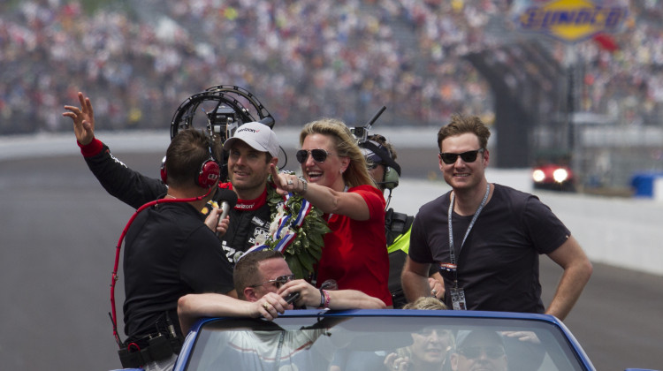 Will Power waves to the crowd with his wife, Elizabeth, during the victory lap after winning the Indianapolis 500 on Sunday.  - Doug Jaggers/WFYI