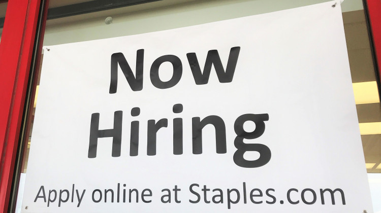 A "Now Hiring" sign on the front of a Staples in Elkhart, Indiana. - Justin Hicks/IPB News