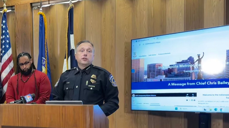 Indianapolis Police Chief Chris Bailey speaks during a media event about the department's new data portal at the City County Building on Thursday, Nov. 20, 2025. Josh Riddick, left, an organizer for the Black Church Coalition, supports the transparency effort. - Zak Cassel / WFYI
