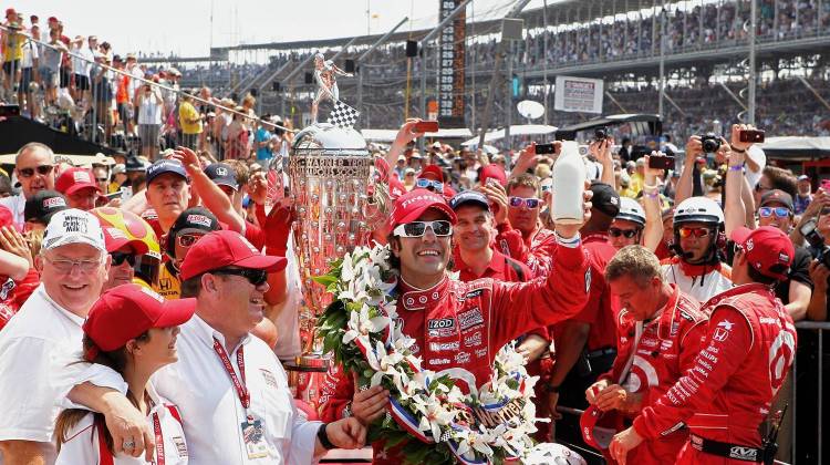 Dario Franchitti hoists the milk in Victory Lane in 2012, which has been offered to every Indy 500 winner since 1956.   - American Dairy Association of Indiana/IMS
