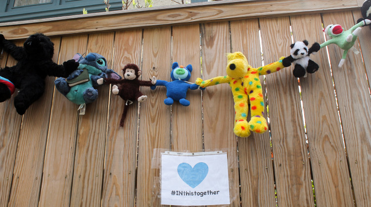 In Indianapolis neighborhoods, a handful of signs in yards and along fences with words of encouragement for neighbors and health care workers. This one includes a chain of stuffed animals. - Lauren Chapman/IPB News