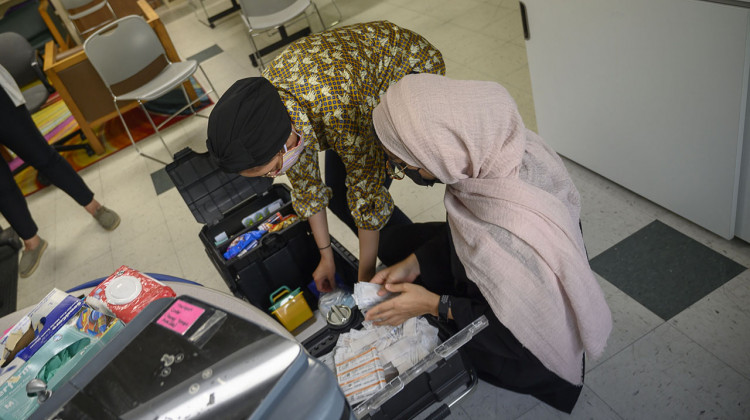 Two volunteers at the University of Iowa mobile clinic set up a COVID-19 vaccination station at the Broadway Neighborhood Center in Iowa City. - (Natalie Krebs/Side Effects Public Media)