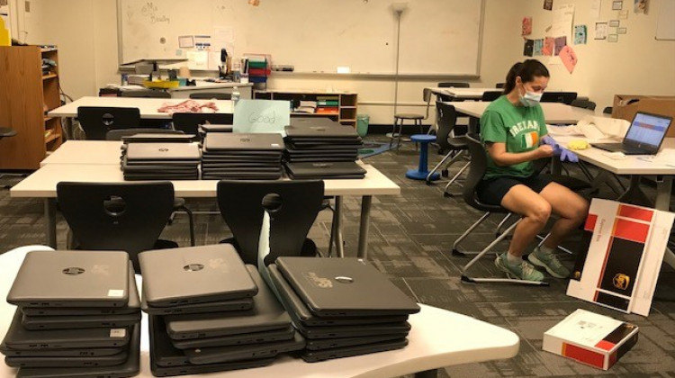 An IPS staff member prepares laptops to be sent to high school students for e-learning. - Indianapolis Public Schools