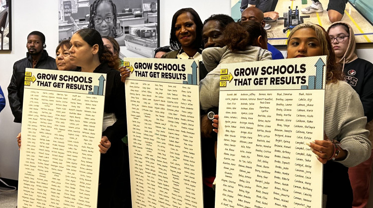 Parents and advocates hold up signs calling for Indianapolis Public Schools to partner with local charter schools with the best outcomes for Black and Brown students. - Eric Weddle/WFYI