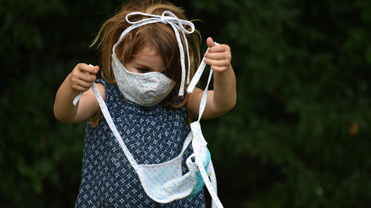 A child plays with a face mask. - Justin Hicks/IPB News