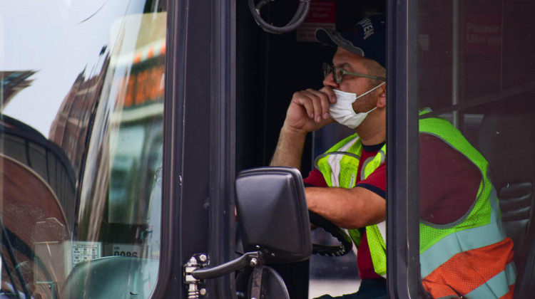A bus driver wearing a mask waits at a light.  - Justin Hicks/IPB News