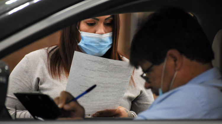 A human resources representative reads a resume at a drive-thru job fair in Elkhart. - Justin Hicks / IPB News