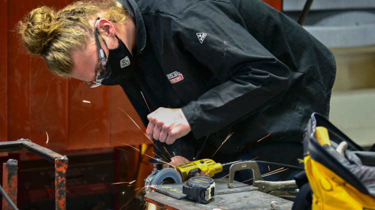 A career and technical education high school student in Elkhart grinds a piece of metal before welding it.  - Justin Hicks/IPB News