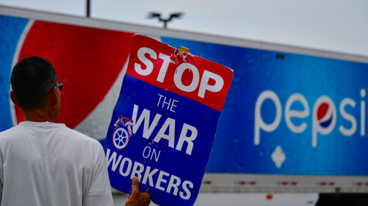 A union worker pickets outside a Pepsi bottling facility in Munster as a truck leaves the driveway. - Justin Hicks/IPB News