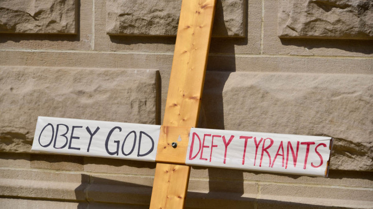 A cross carried at a protest on the lawn of the Indiana Statehouse in opposition to vaccination requirements from government. (Justin Hicks/IPB News)