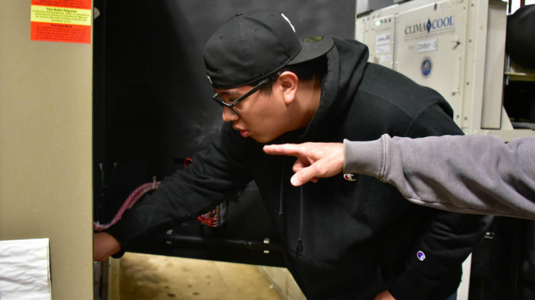 A maintenance high school apprentice with Indianapolis Public Schools works on a heating unit. - Justin Hicks/IPB News