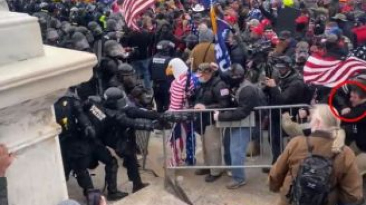 Koen, circled in red on the right, captured in footage wrestling a barricade from an officer's hands. - Via Statement of Facts document from Unites States Attorney's office.