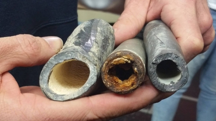 An Environmental Protection Agency civil engineer shows how corrosion control treatments can affect lead pipes. The one on the left was treated, the middle one was not, and the one on the right is a new pipe. - Lauren Chapman/IPB News