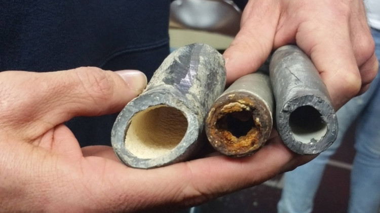 An EPA civil engineer shows how corrosion control treatments can affect lead pipes. The one on the left was treated, the middle one was not, and the one on the right is a new pipe - Lauren Chapman/IPB News