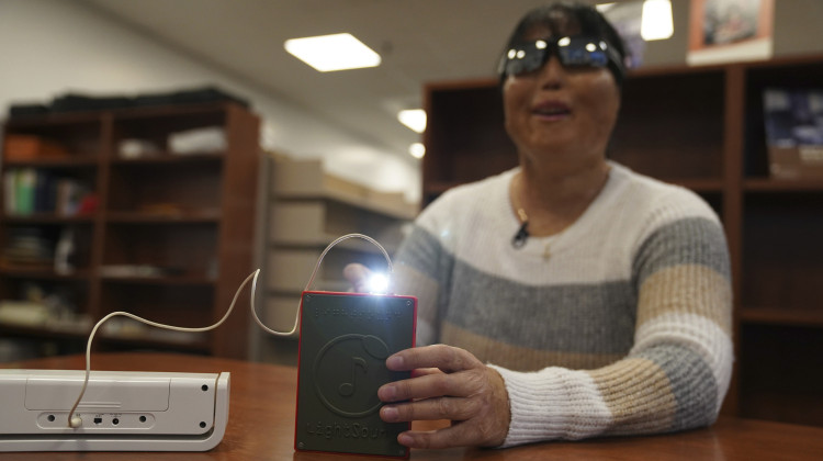 Minh Ha, assistive technology manager at the Perkins School for the Blind tries a LightSound device for the first time at the school's library in Watertown, Mass., on March 2, 2024. - Mary Conlon / AP Photo
