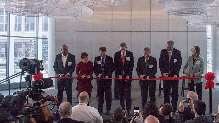 City council member Vop Osili, Cummins VP Marya Rose, Indianapolis Mayor Joe Hogsett, Cummins CEO Tom Linebarger, VP Tony Satterthwaite, Gov.-elect Eric Holcomb, and Head Architect Deborah Berke cut the ribbon illustrating the completion of the newest building in Indianapolis. - Logan Macaluso/TheStatehouseFile.com