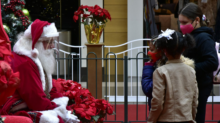 Santa, wearing a face shield, speaks with children wearing cloth face masks at the University Park Mall in Mishawaka.  - Justin Hicks/IPB News