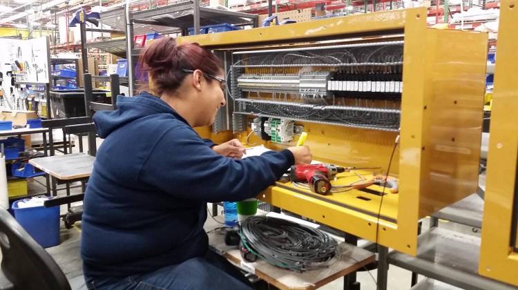 Alondra Pelaez, 29, tests wiring connections inside an unfinished control panel at the Kirby Risk factory in Lafayette. - Annie Ropiek/WBAA/File