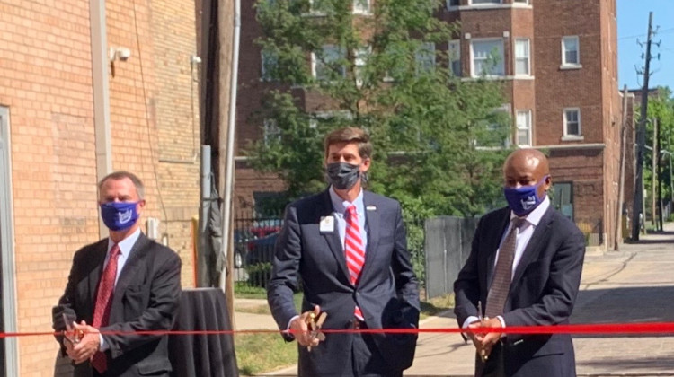 Indianapolis Mayor Joe Hogsett (left); Charles Hyde, president and CEO of the Benjamin Harrison Presidential Site (middle); and City-County Council President Vop Osili (right) get ready to cut the ribbon celebrating the completion of the Talbott and 12th streets project. - Robert Moscato-Goodpaster/WFYI