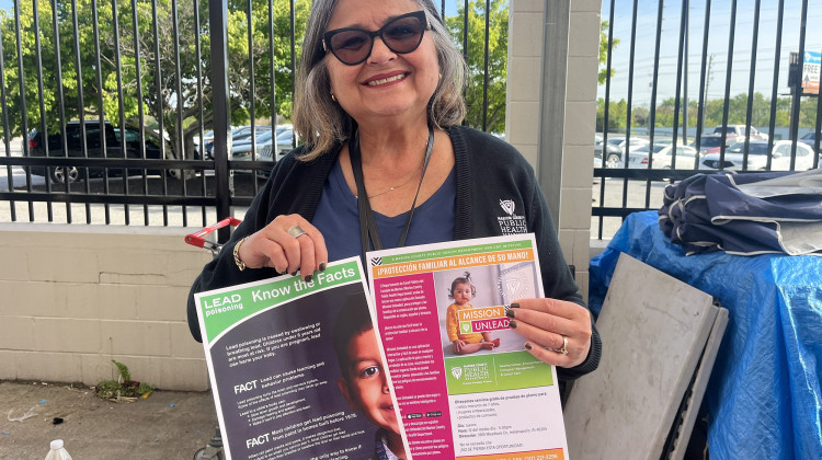 Maryori Duarte-Sheffield, a health educator for the Marion County Public Health Department holds up lead exposure resources at an immigration fair. - Violet Comber-Wilen / IPB News