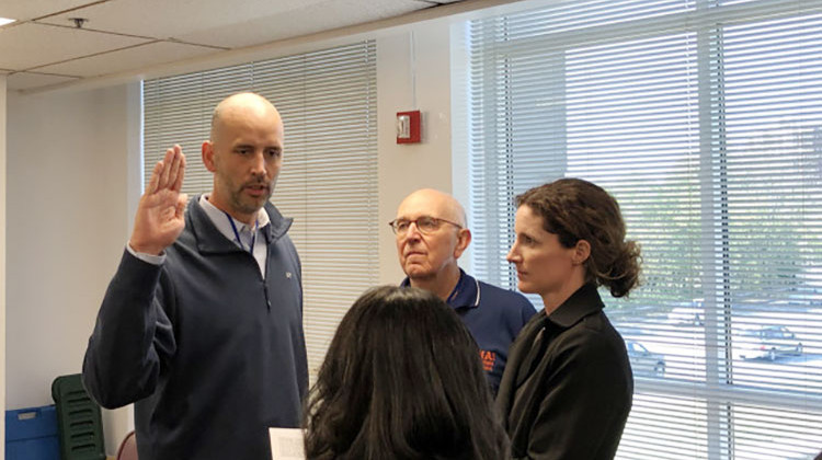 Ryan Mears takes an oath into office. He is joined by former county prosecutor Terry Curry and wife, Shannon Mears.   - Darian Benson/WFYI