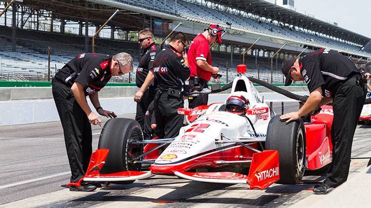 Team Penske crew members look over the No. 2 Verizon Chevrolet as Juan Pablo Montoya sits in the car.   - Doug Jaggers