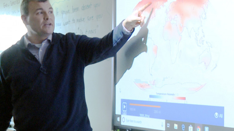 Keith Morey at Centerville-Abington Junior High points to an animated NASA map showing how average temperatures have changed since the late 1800s.  - Tyler Lake, WTIU
