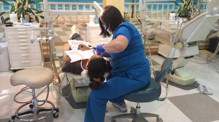 A hygienist numbs a patient in preparation for a tooth extraction at Smiles of Hope. - Marissanne Lewis-Thompson/KRCU