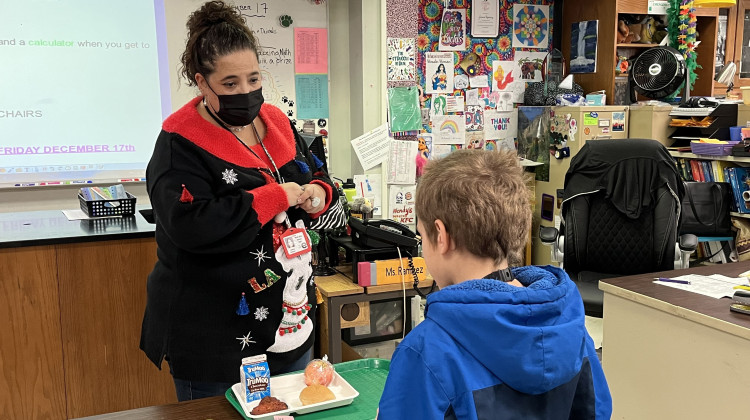 Jessica Ramirez, pictured in her classroom at Northside Middle School in Elkhart, Indiana, in December 2021, works with a student during lunch hour. Ramirez is a veteran special educator. She said the struggle to hire special education paraprofessionals makes it harder for educators to do their jobs. - Dylan Peers McCoy/WFYI