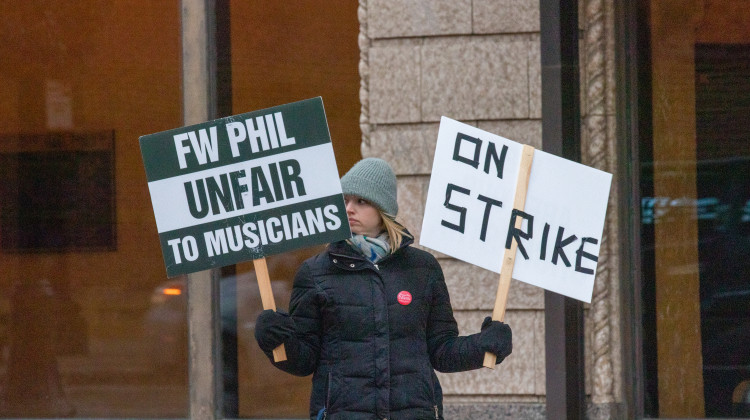 One Philharmonic musician holds up signs during a picket in front of the Embassy on Friday, January 6, 2023. Musicians have been on strike since December 8, 2022. - Brittany Smith / WBOI News