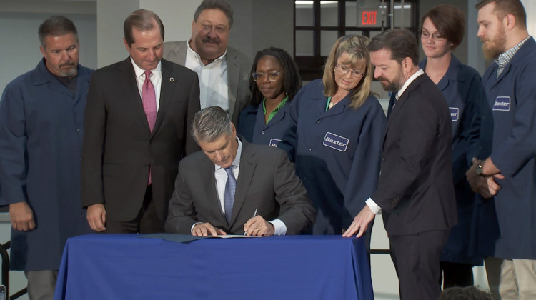 Baxter CEO Joe Almeida signs the Trump administration's "Pledge To America's Workers." U.S. Health and Human Services Secretary Alex Azar traveled to Indiana Friday as part of the signing. - Seth Tackett/WTIU