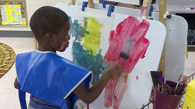 A student paints on an easel at Day Early Learning in Indianapolis. This preschool is run by Early Learning Indiana, which is advocating for state funded pre-k for low income families.  - Claire McInerny/Indiana Public Broadcasting