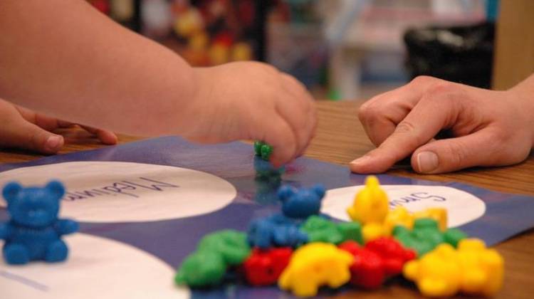 A child's hand grabs a toy in a preschool classroom. - Flickr