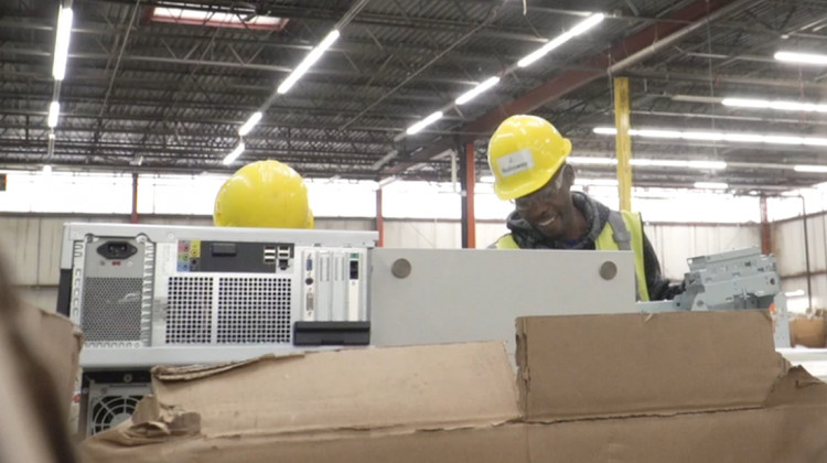 Workers at RecycleForce in Indianapolis take apart electronics. - Alan Mbathi/IPB News