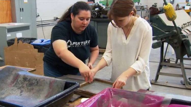 Veteran and Herron School of Art student Shanna Reis, left, helps a fellow Combat Paper workshop participant.