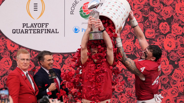 Indiana head coach Curt Cignetti holds the winner's trophy as he is doused with rose pedals by linebacker Aiden Fisher (4) after a win over Alabama in the Rose Bowl College Football Playoff quarterfinal game Thursday, Jan. 1, 2026, in Pasadena, Calif.  - Mark J. Terrill / AP Photo