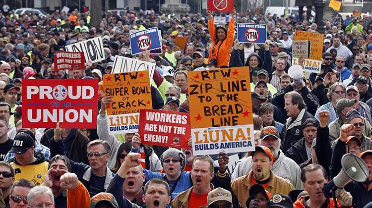 In this file photo, union protestors gather outside the Statehouse after the Senate voted to pass the right-to-work bill in Indianapolis, Wednesday, Feb. 1, 2012. - AP Photo/Michael Conroy