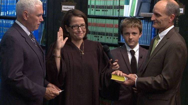 Gov. Mike Pence swears in Loretta Rush as Chief Justice of the Indiana Supreme Court, as her son Luke and husband Jim, look on. - Brandon Smith