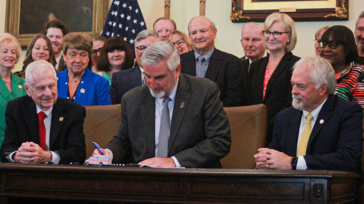 Gov. Eric Holcomb ceremonially signs SB4, the public health system overhaul bill, on Wednesday, May 24, 2023. Supporters of the law, including former Sen. Luke Kenley and State Health Commissioner Dr. Kristina Box (directly behind and to the right of Holcomb), look on. - Brandon Smith/IPB News